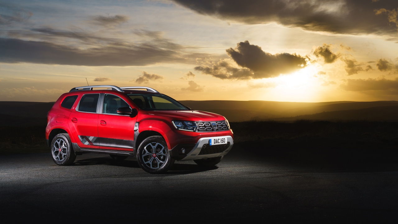 Красный внедорожник Dacia Duster Techroad 2019 года на фоне неба на закате