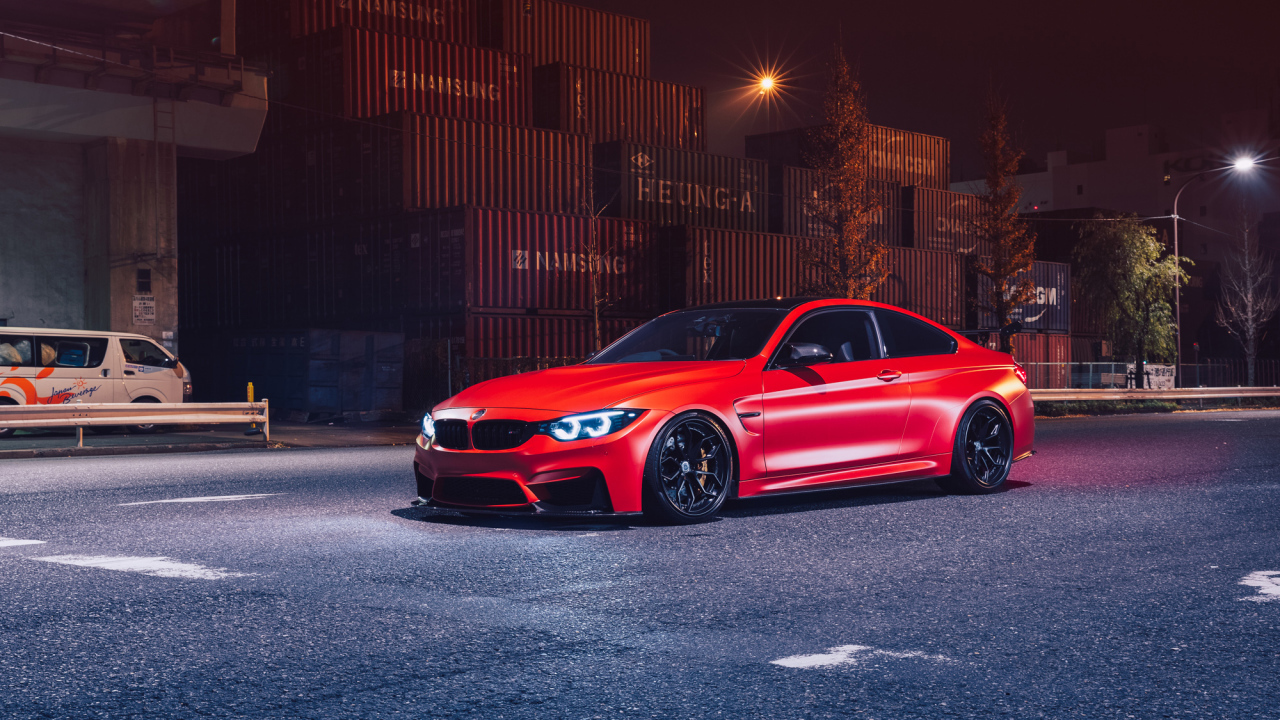 Красный автомобиль BMW M4 на фоне контейнеров