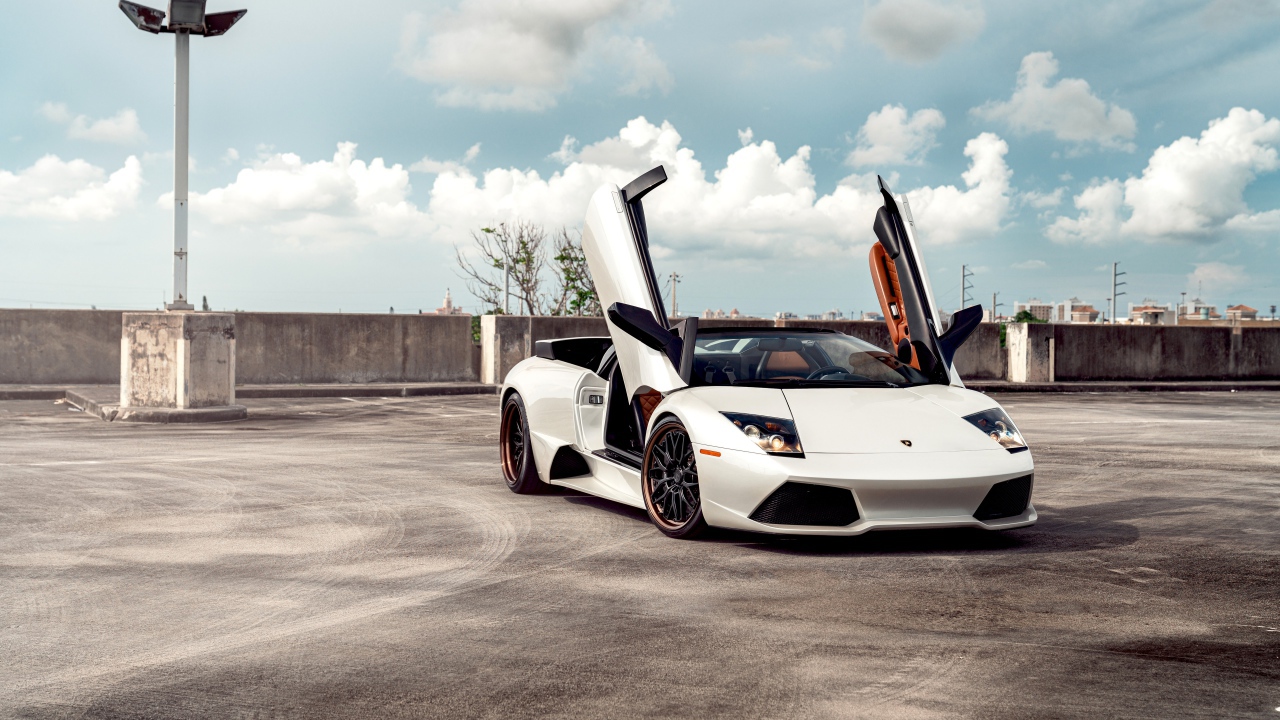 Белый автомобиль Lamborghini Murcielago с открытыми дверями