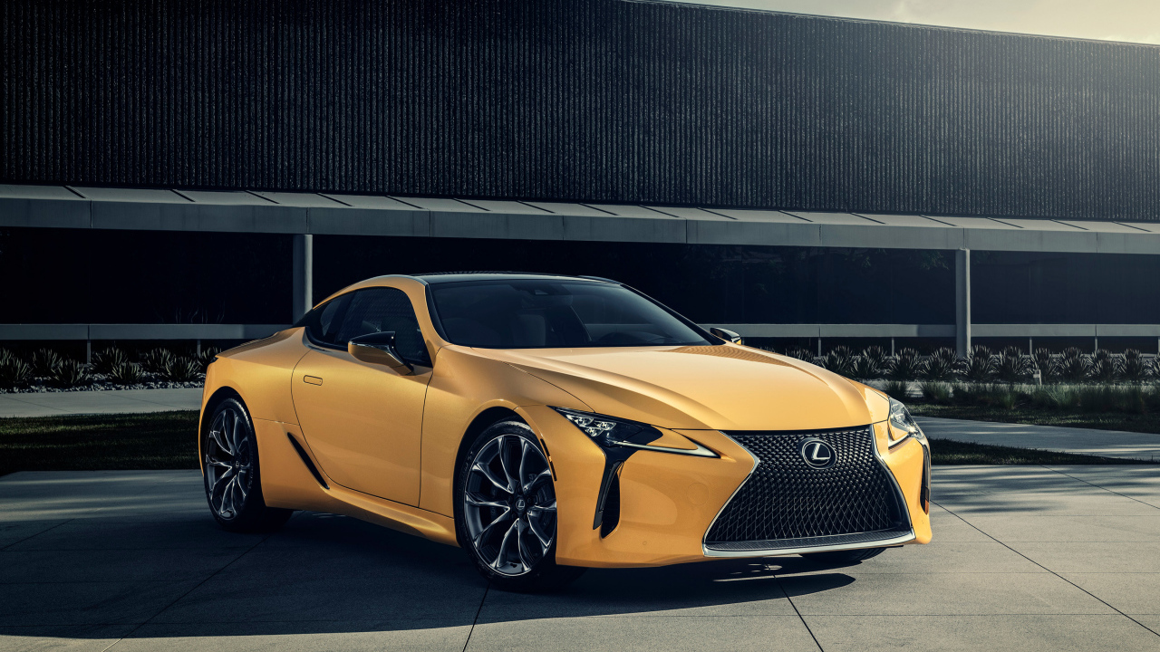 Желтый автомобиль Lexus LC 500 на фоне стены