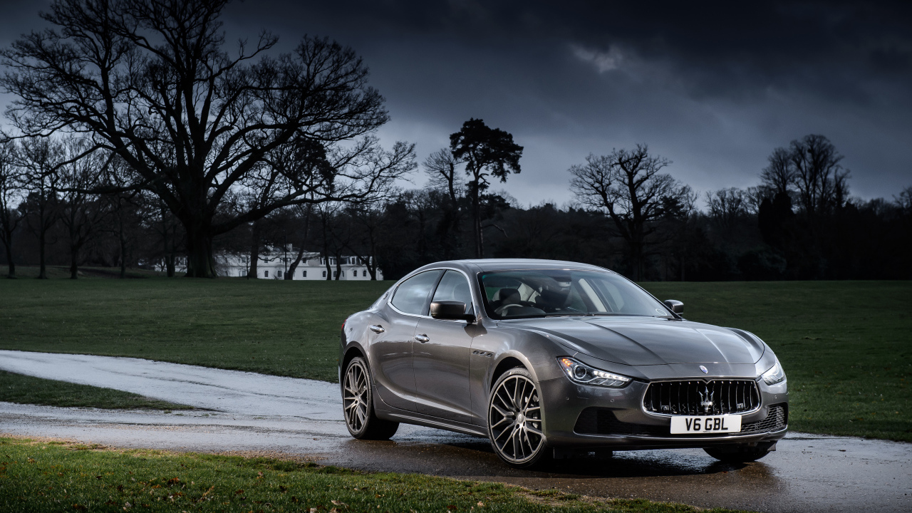 Серебристый автомобиль Maserati Ghibli на фоне грозового неба