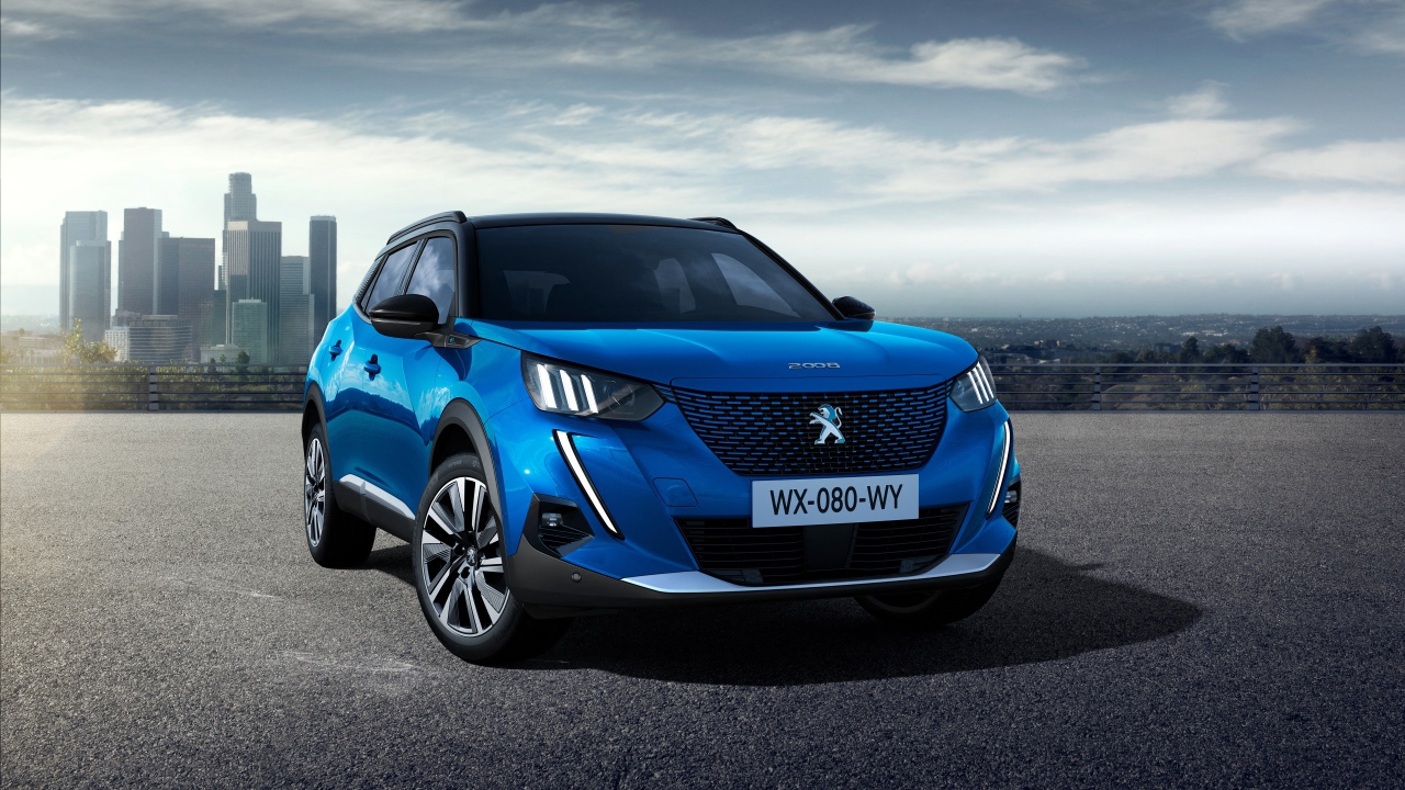 Синий внедорожник Peugeot E-2008 GT, 2019 года на фоне небоскребов