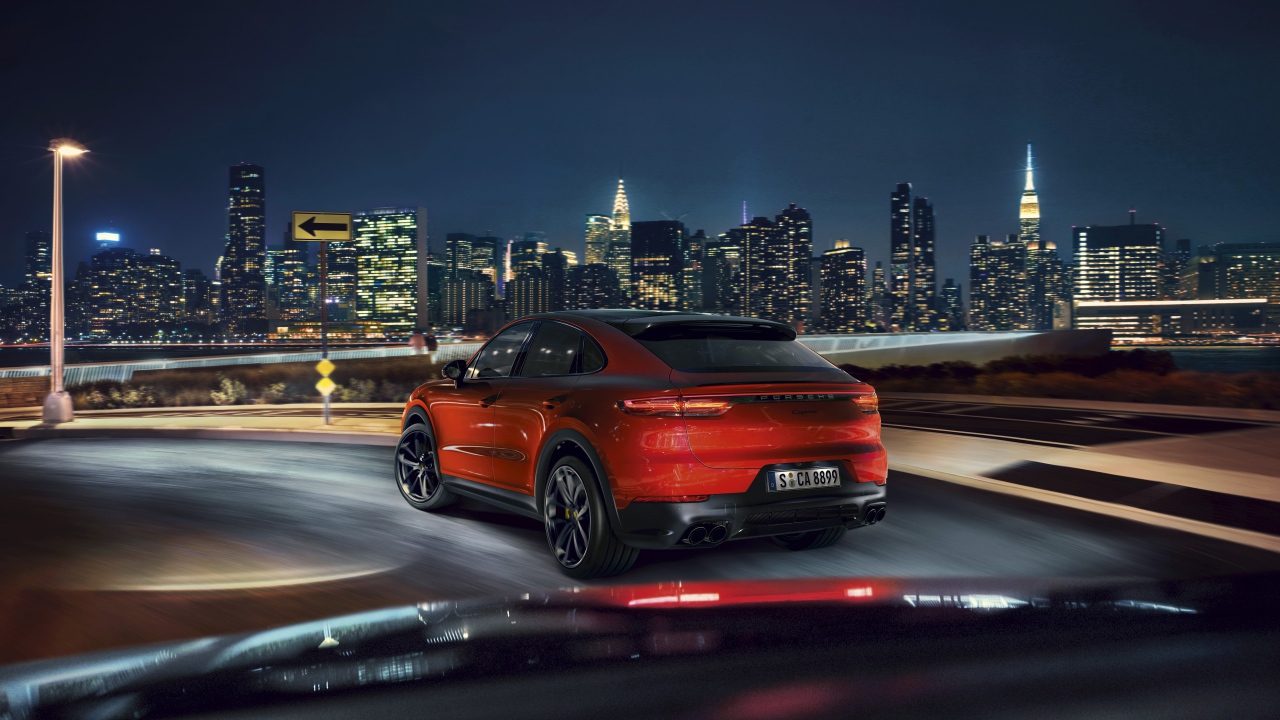 Красный внедорожник Porsche Cayenne Coupe 2019 года на фоне города