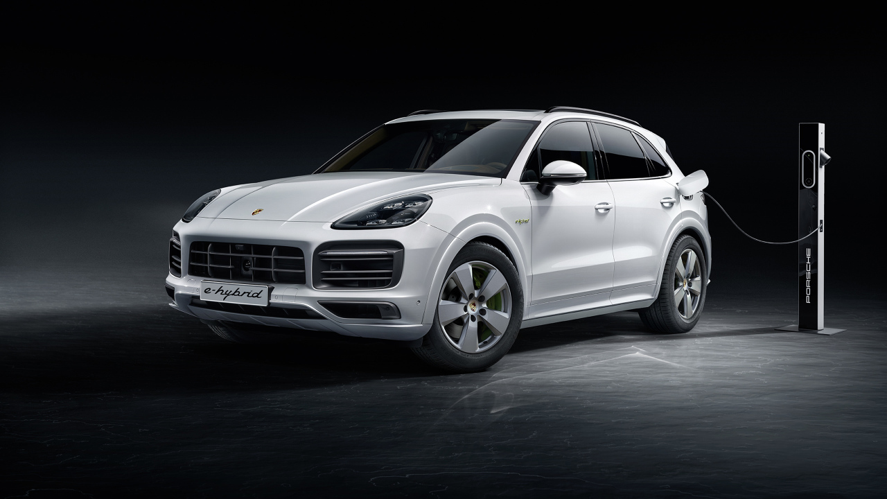 Белый внедорожник Porsche Cayenne E-Hybrid 2018 года на заправке 