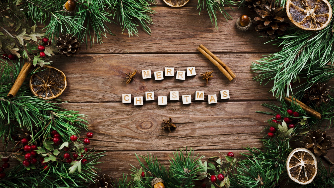 Надпись Merry Christmas на деревянном столе с еловыми ветками 
