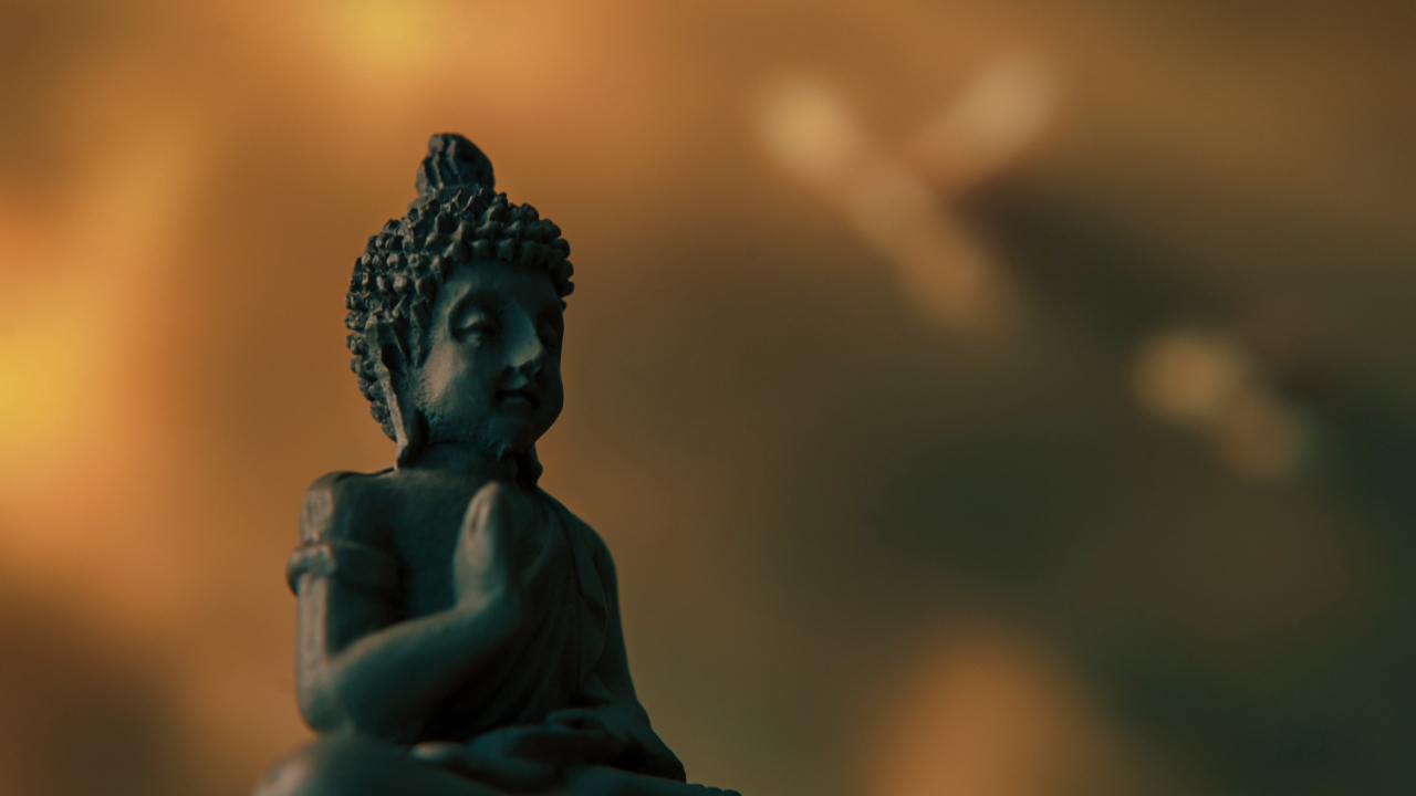 Статуэтка Будда на коричневом фоне крупным планом