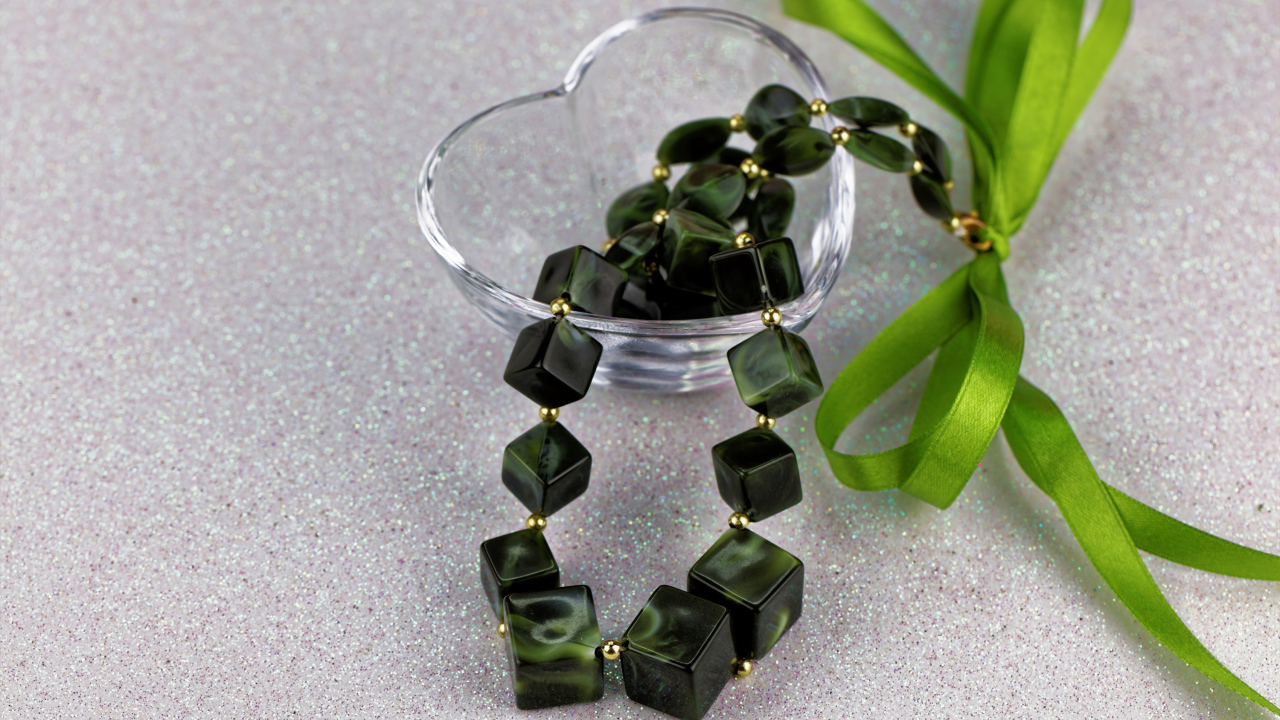 Ювелирное изделие с  бантиком в стеклянной вазочке на столе