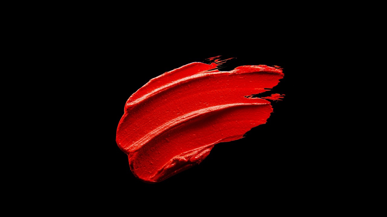 Мазок красной краски на черном фоне