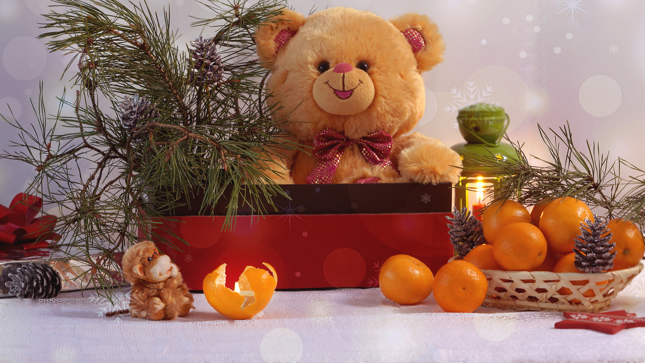 Медвежонок Тедди в коробке с еловой веткой на столе с мандаринами 