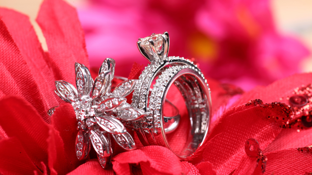 Два кольца с камнями лежат на цветке 