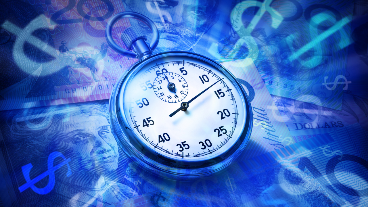 Секундомер лежит на купюрах разных стран 