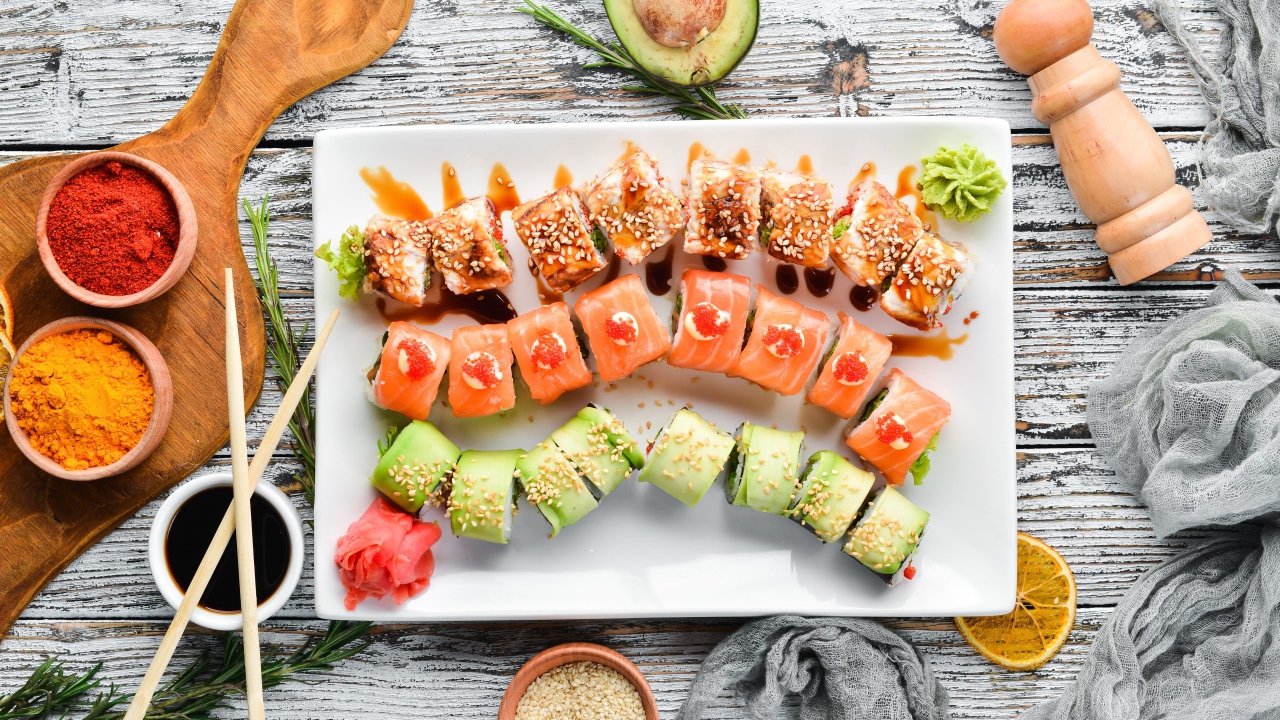Вкусные аппетитные японские роллы на столе с соусом и специями