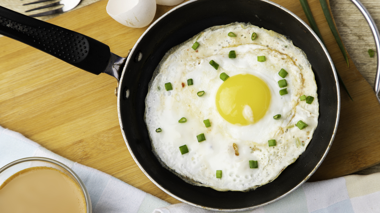 Яичница глазунья на сковороде с зеленым луком