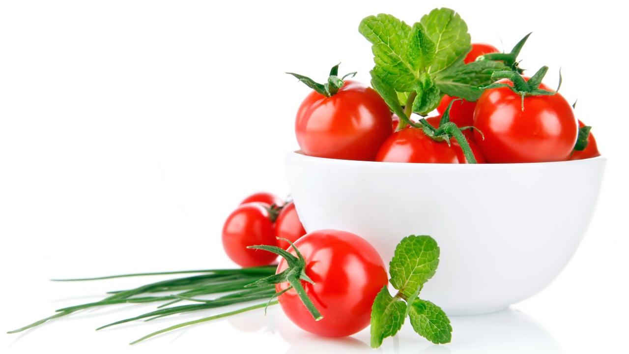 Красные помидоры с зеленым луком на белом фоне