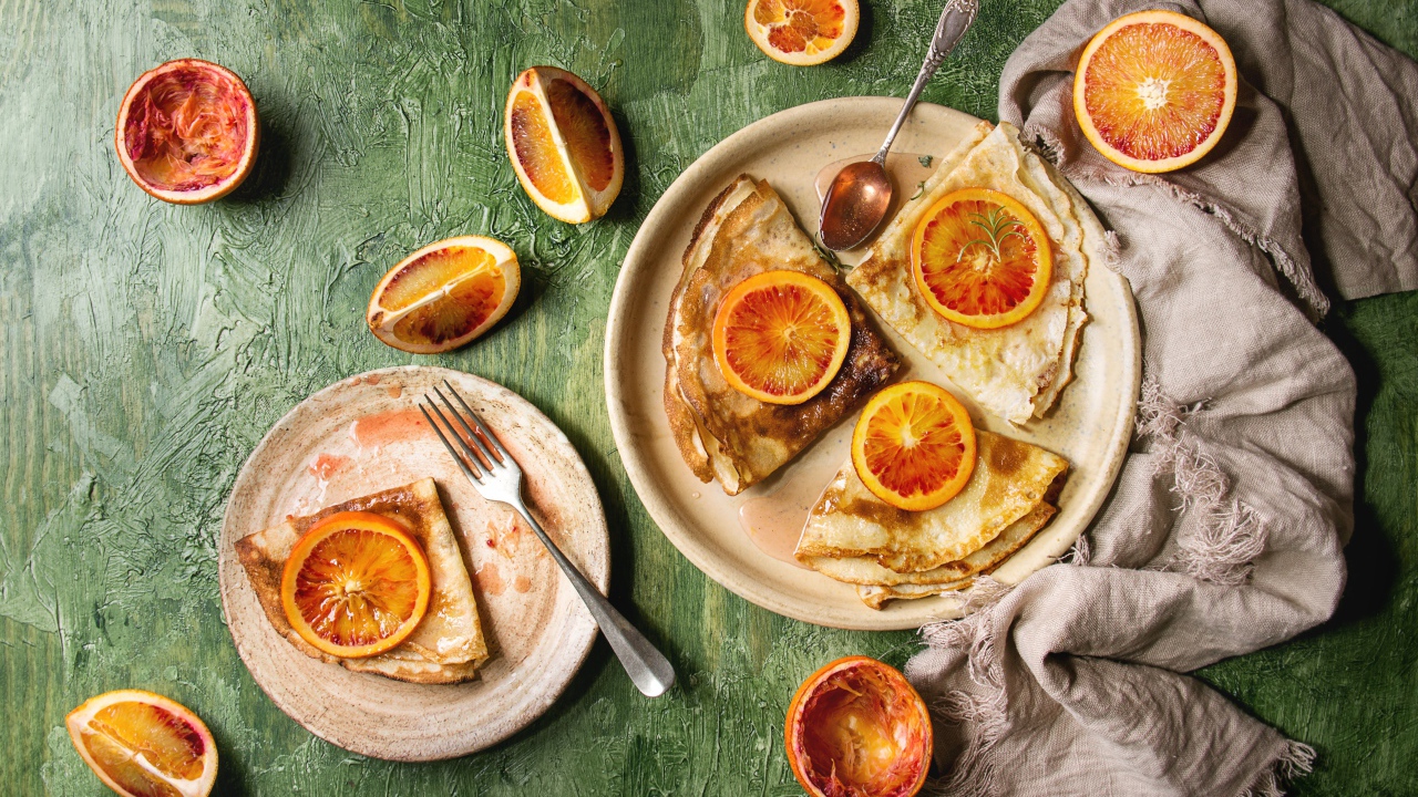 Тонкие блинчики с апельсинами на столе