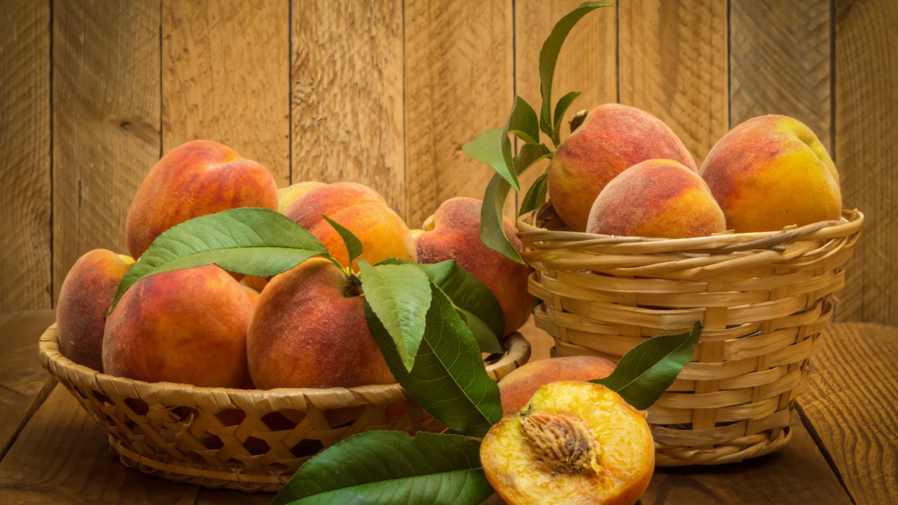 Аппетитные сочные спелые персики в корзинках на столе