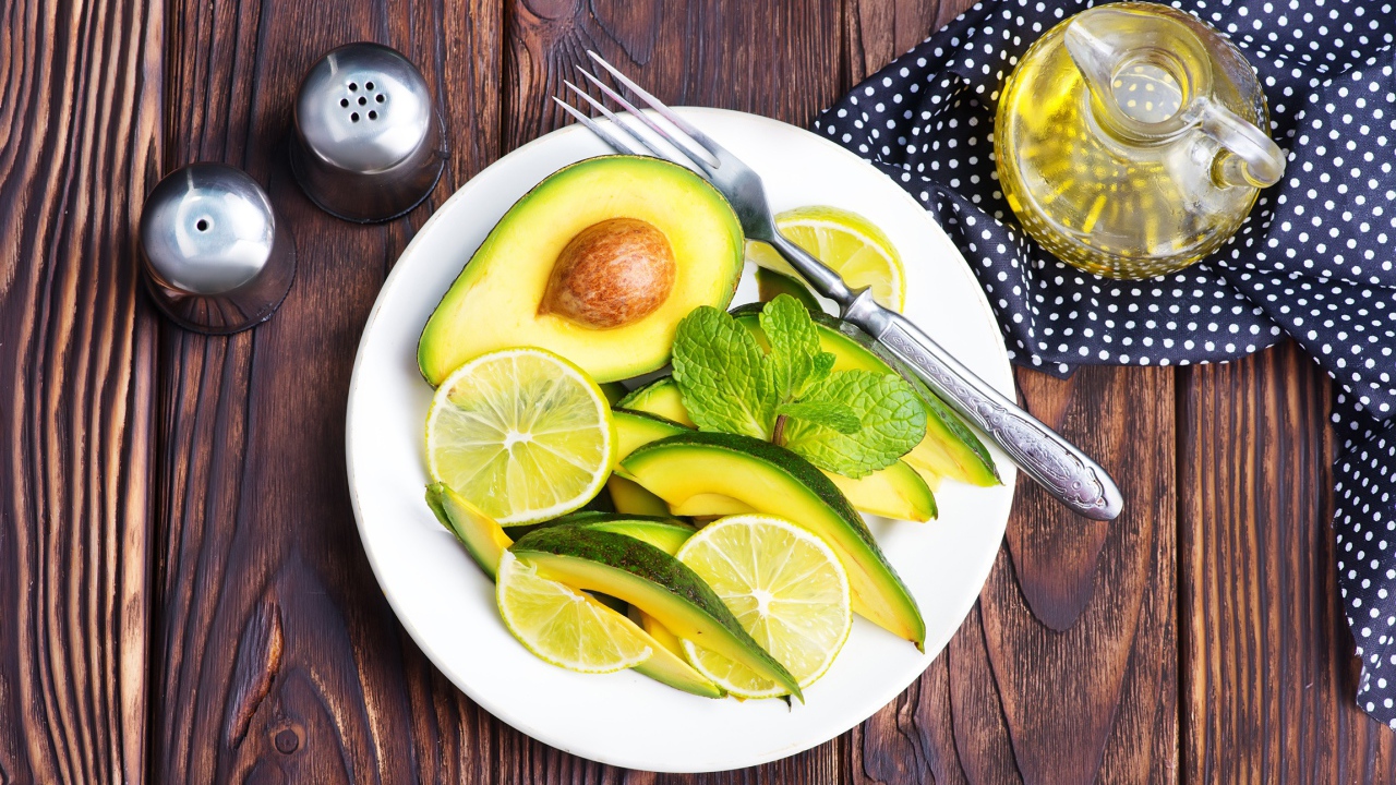 Авокадо и лимон нарезанный кусочками на тарелке