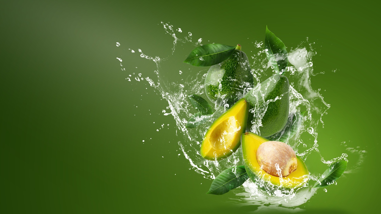 Авокадо в воде на зеленом фоне