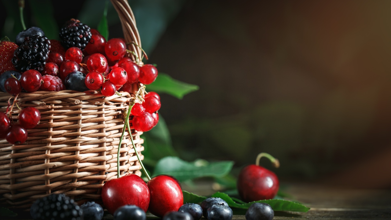 Корзина с ягодами черники, малины, красной смородины и черешни