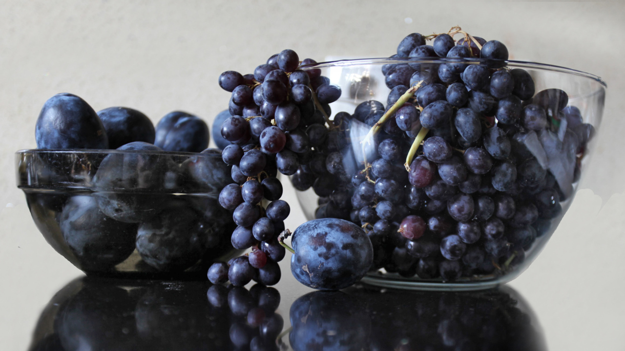 Синий виноград с синими сливами на столе