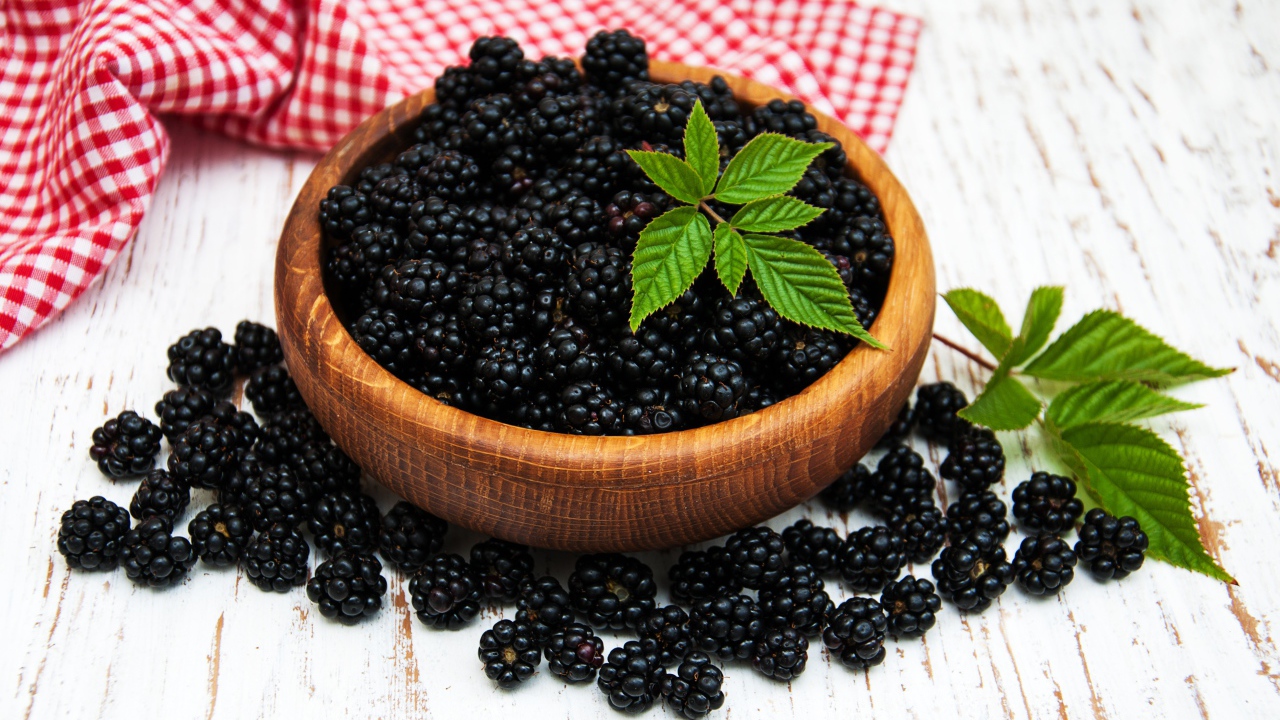 Спелая черника в деревянной миске на столе
