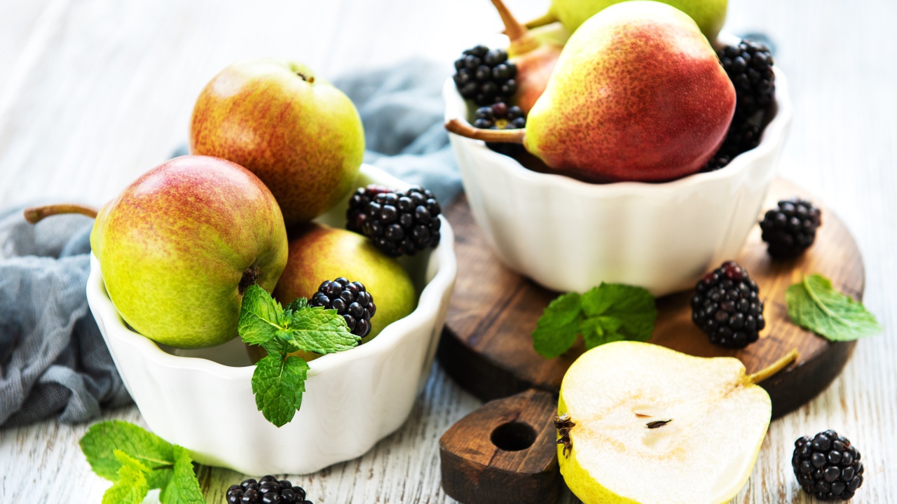 Вкусные груши на столе с ягодами ежевики