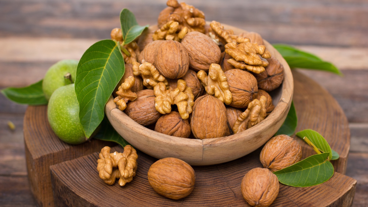 Грецкие орехи в миске на деревянной доске