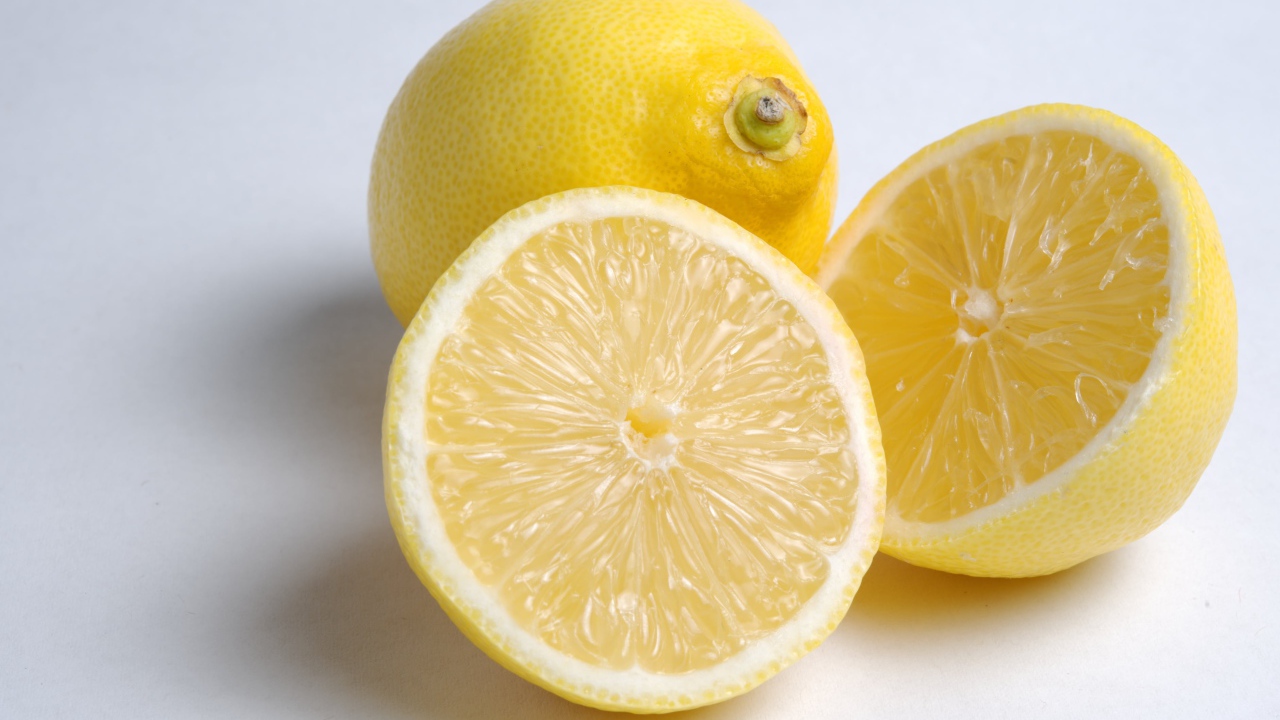 Желтые кислые лимоны на сером фоне