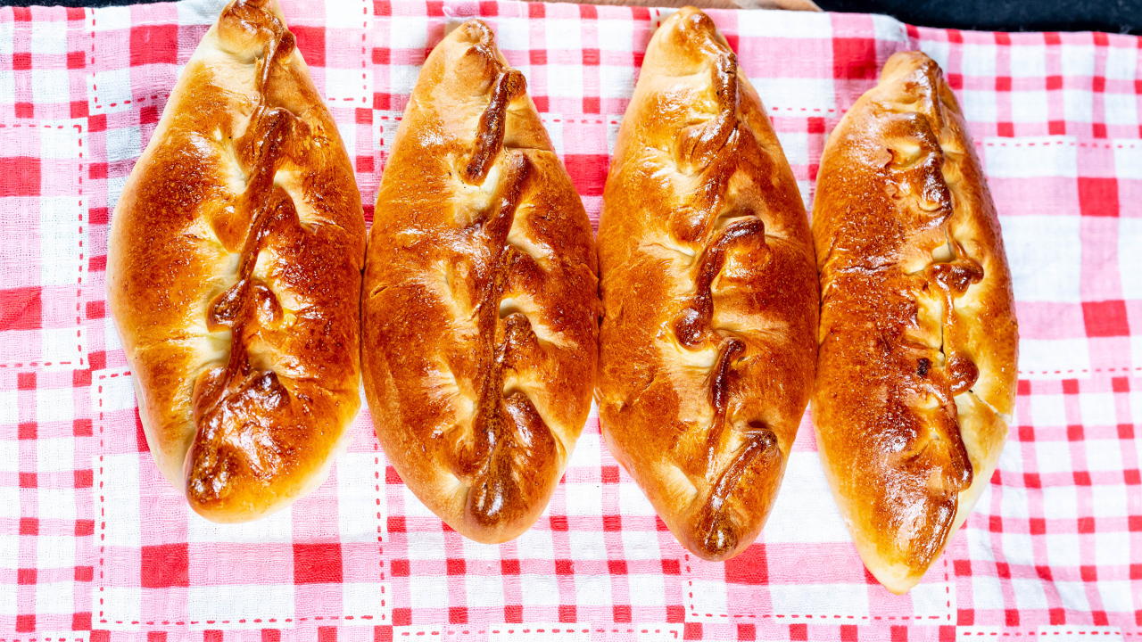 Аппетитные румяные пирожки лежат на полотенце 