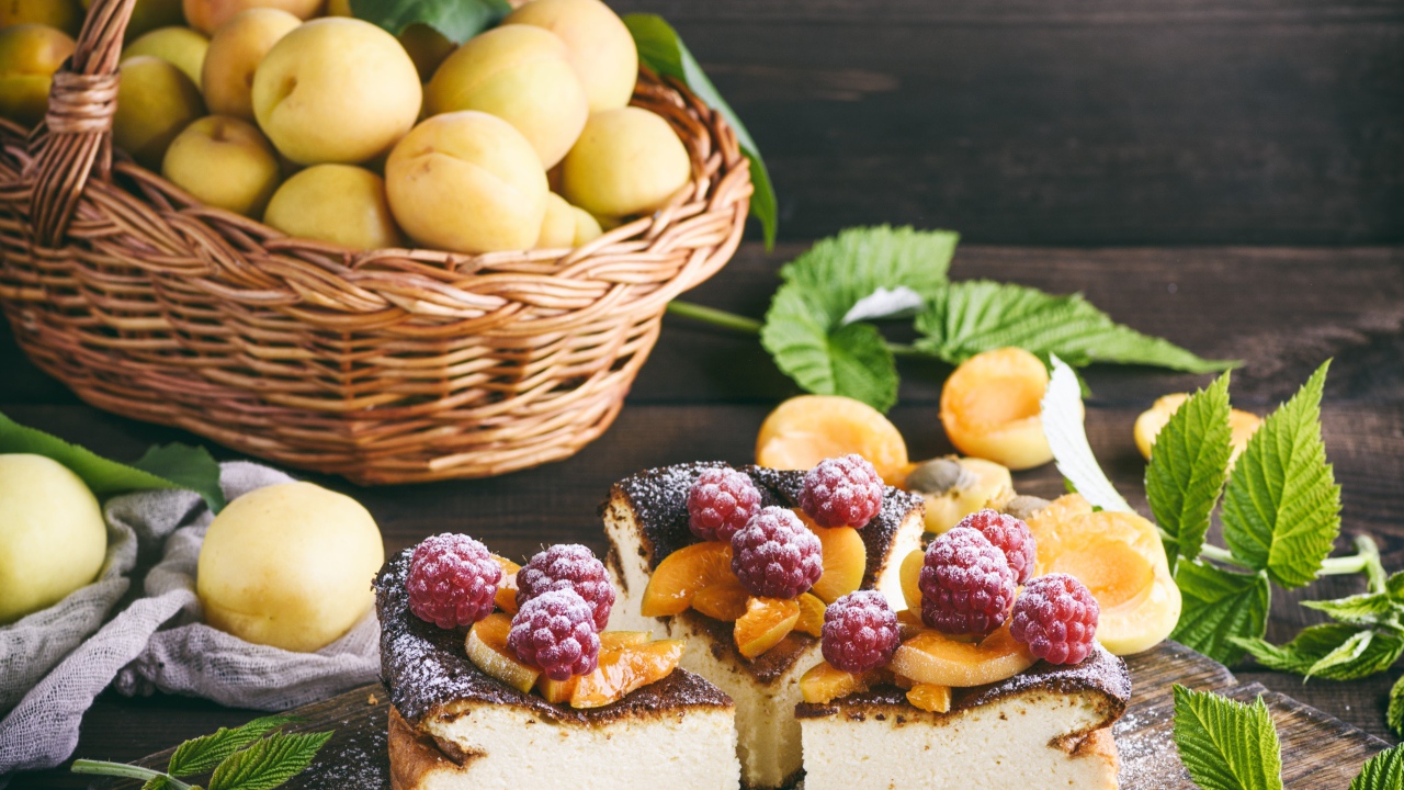 Вкусный фруктово - ягодный пирог на столе с корзиной с абрикосами