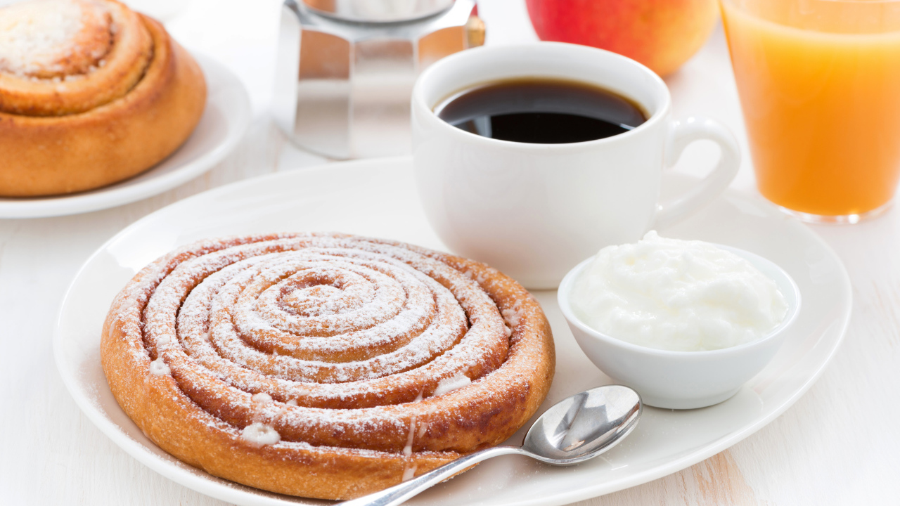 Чашка кофе на тарелке с выпечкой и сливками