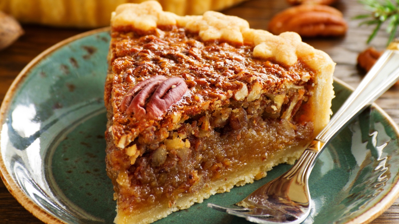 Кусок пирога с орехами на тарелке с вилкой