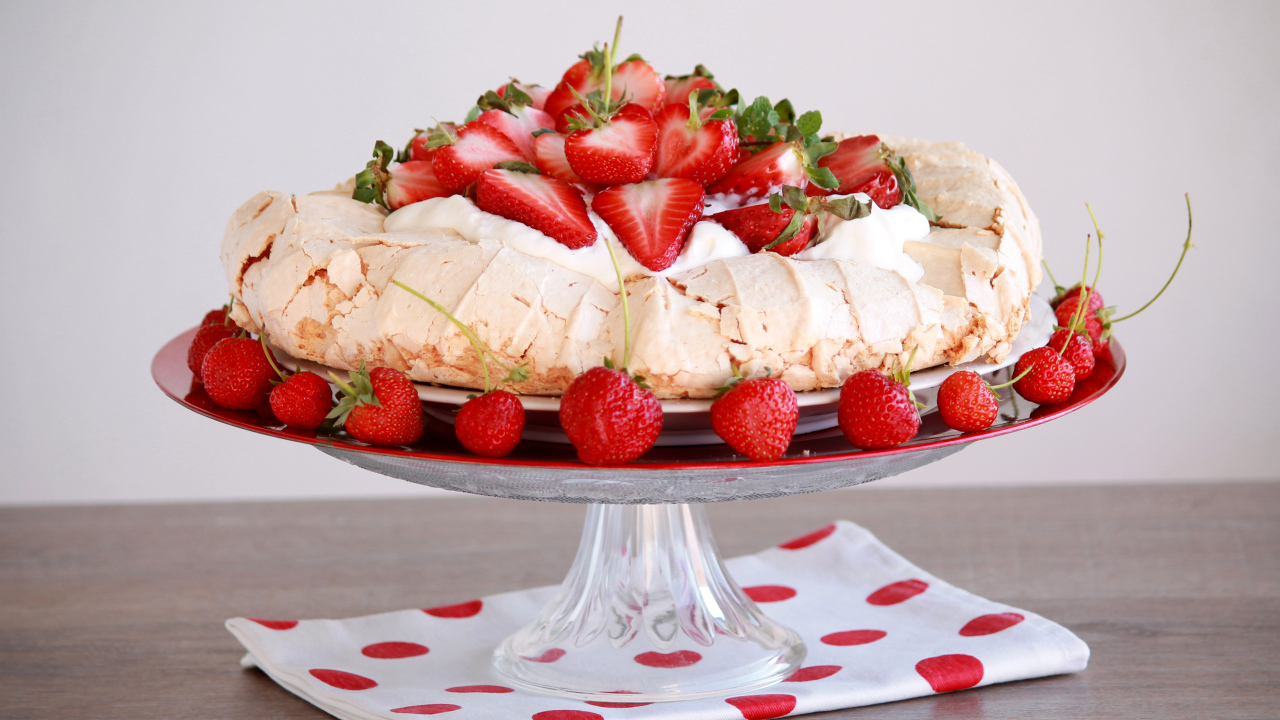 Аппетитный десерт Павлова на блюде с клубникой