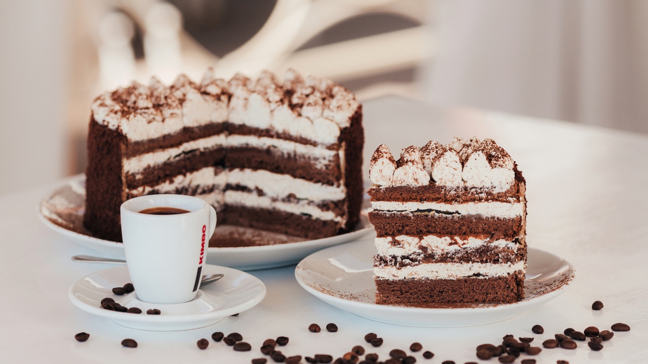 Аппетитный торт с чашкой кофе на столе