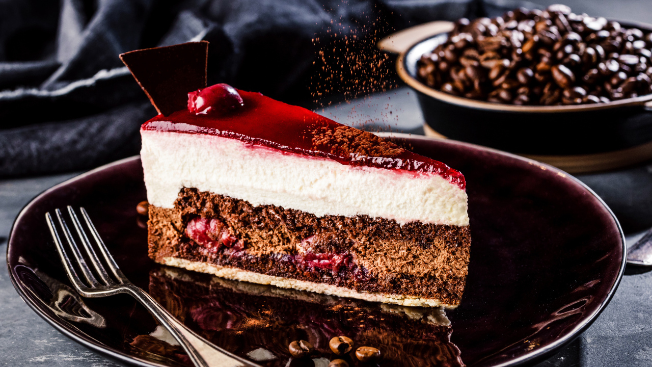 Аппетитный торт с суфле и вишнями на столе с кофейными зернами