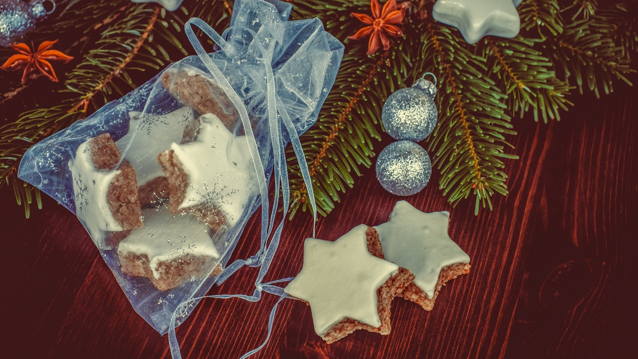 Аппетитное печенье звездочки в мешочке на столе с еловой веткой