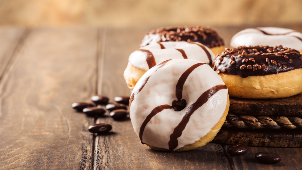 Аппетитные сладкие пончики с глазурью на столе