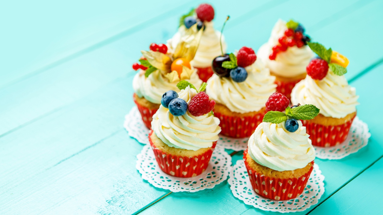 Кексы со взбитыми сливками украшены ягодами