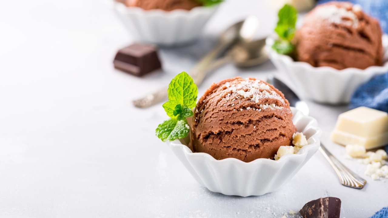 Шарик шоколадного мороженого с мятой на столе с шоколадом