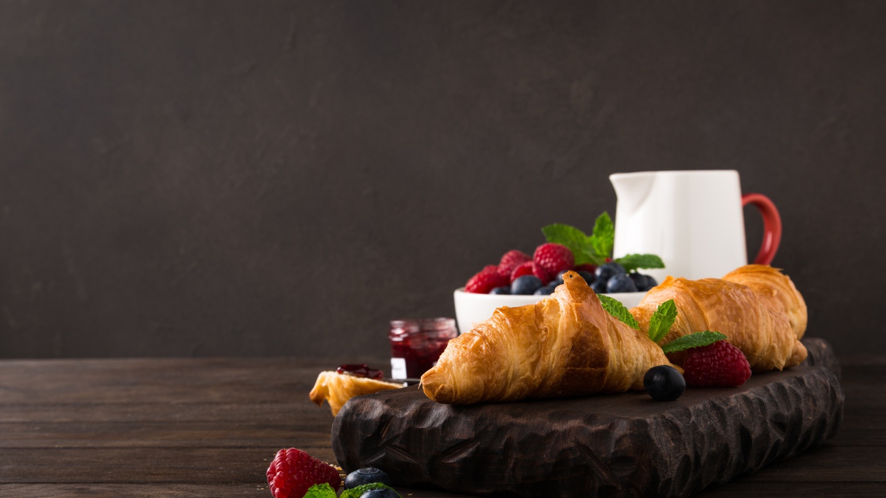 Круассаны на столе с ягодами и джемом 