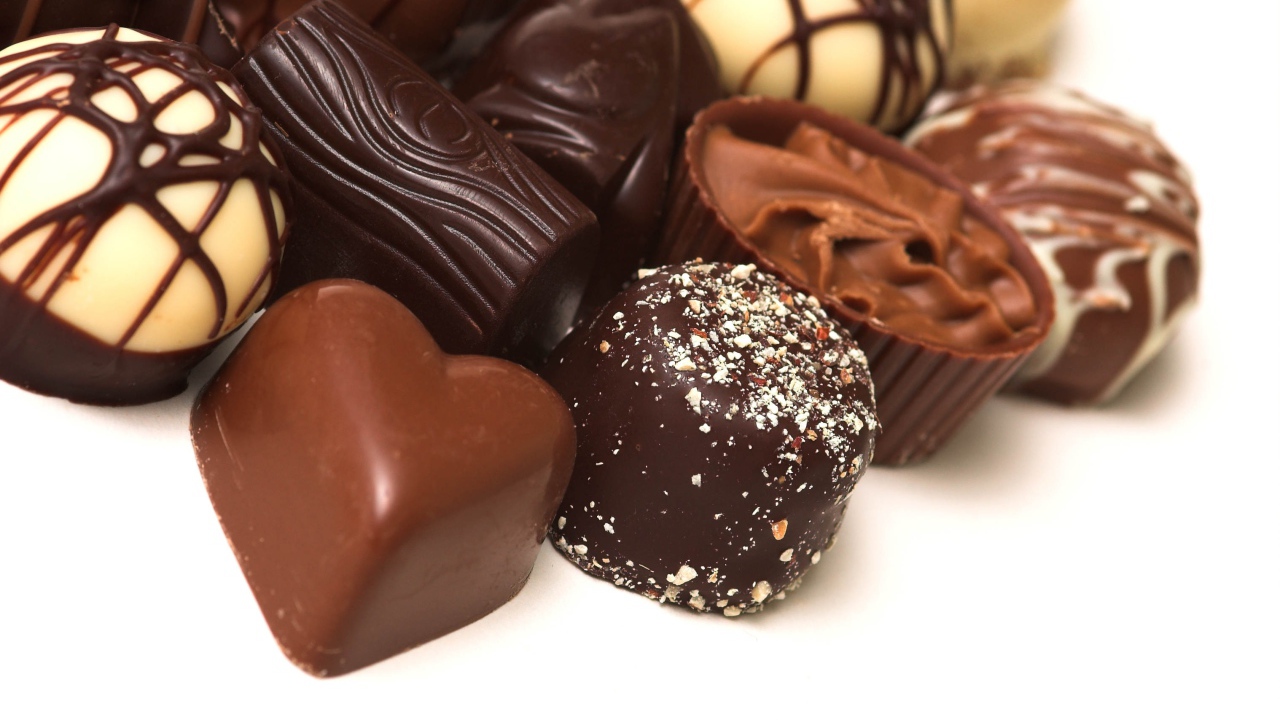 Разные шоколадные конфеты на белом фоне 