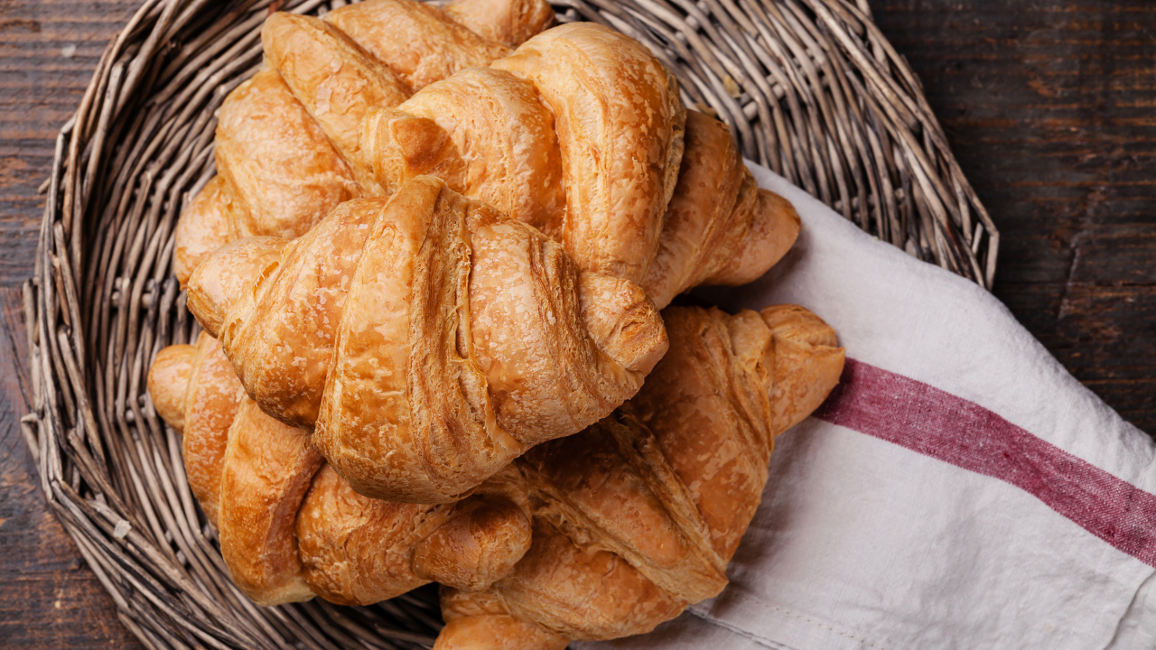 Свежие круассаны в корзинке с полотенцем