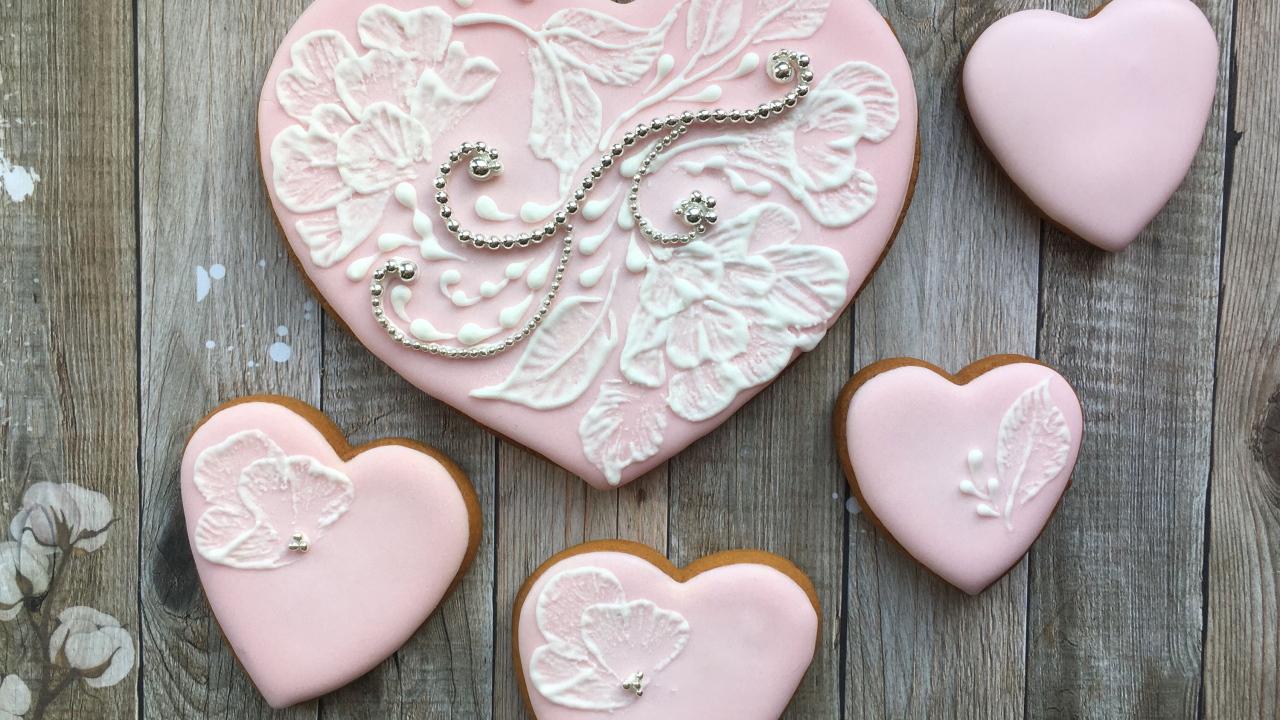Печенье в форме сердца с розовой глазурью на столе