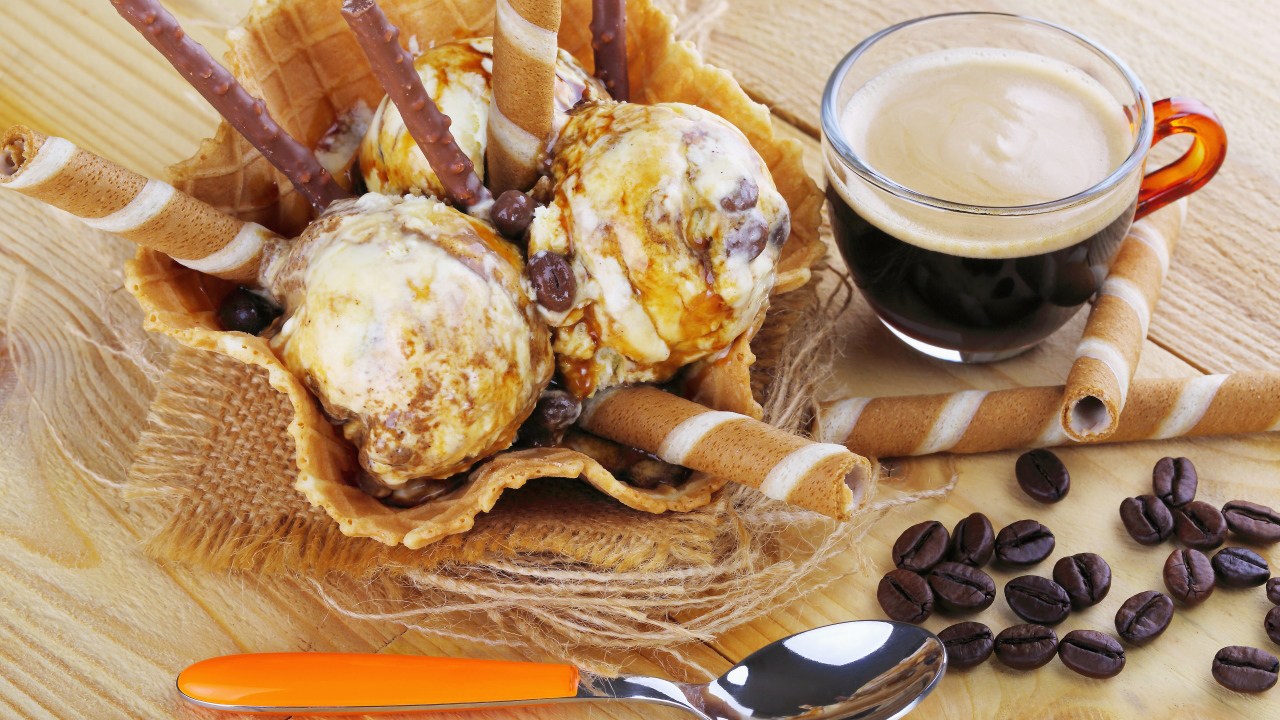 Мороженое с трубочками на столе с кофейными зернами и кофе