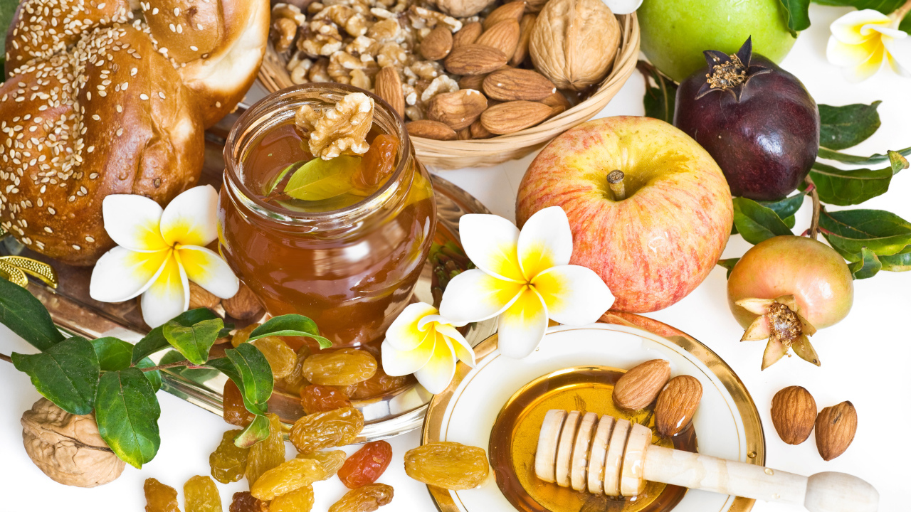 Орехи, мед, яблоки и выпечка с изюмом на столе к празднику