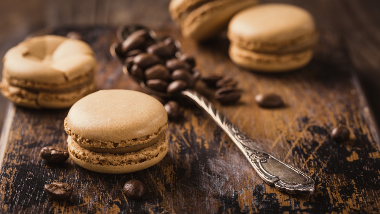 Печенье макарон на столе с ложкой и кофейными зернами