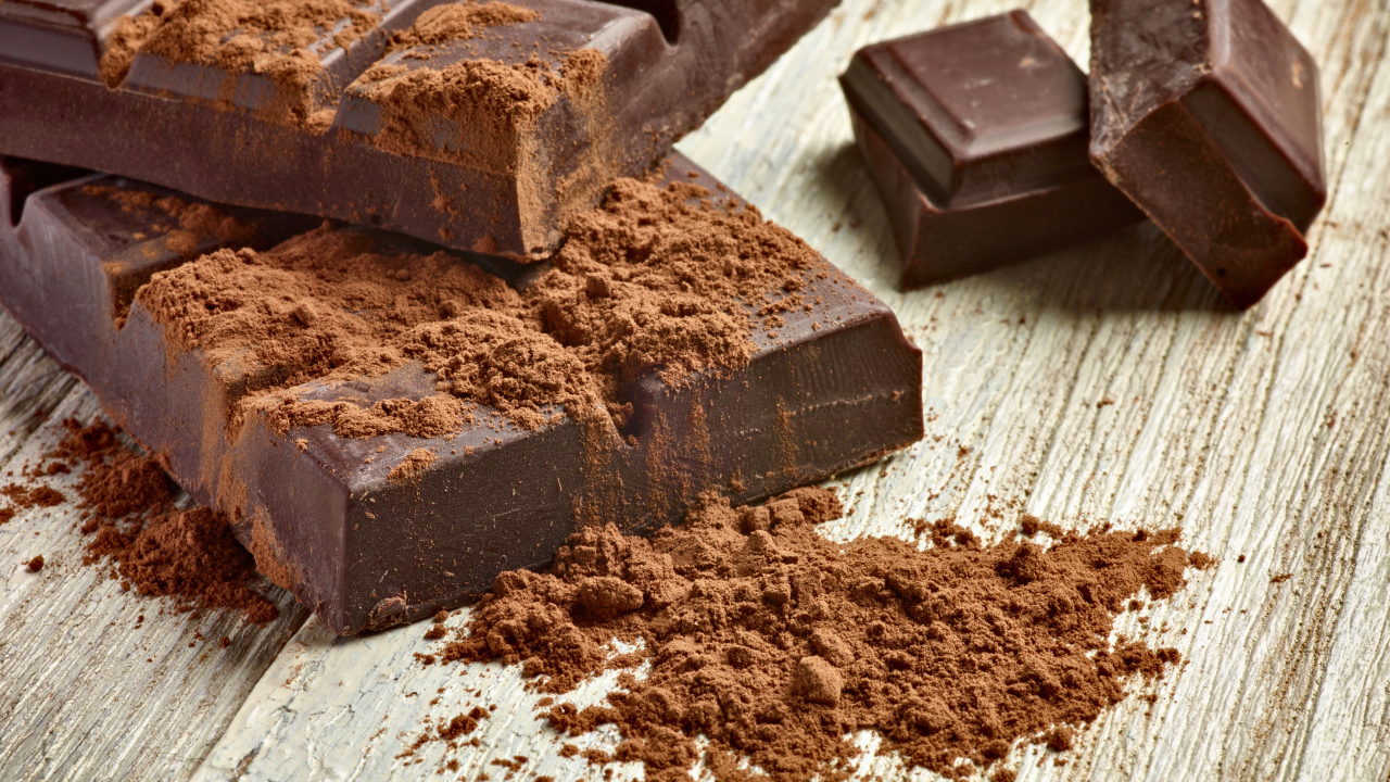 Куски шоколада с какао на деревянном столе 