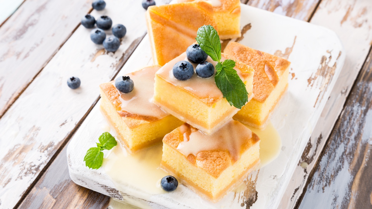 Бисквитные пирожные с сиропом и ягодами черники на столе