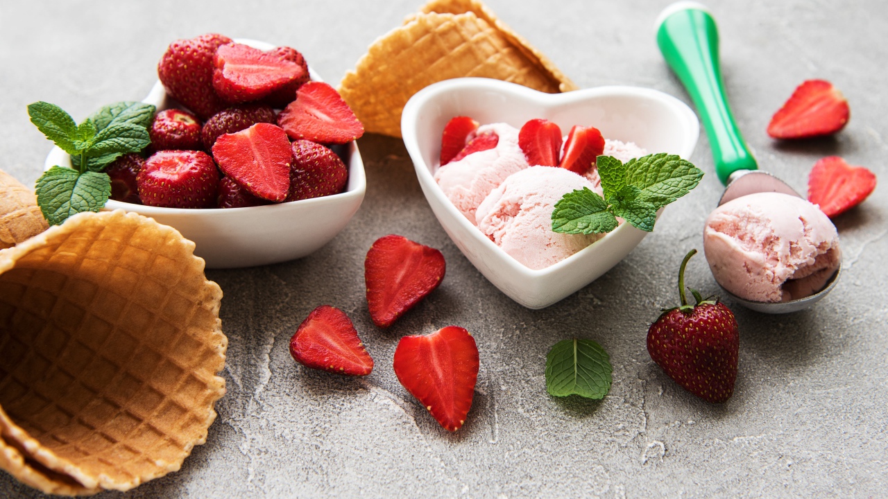 Вкусное мороженое на столе с клубникой и вафельными рожками