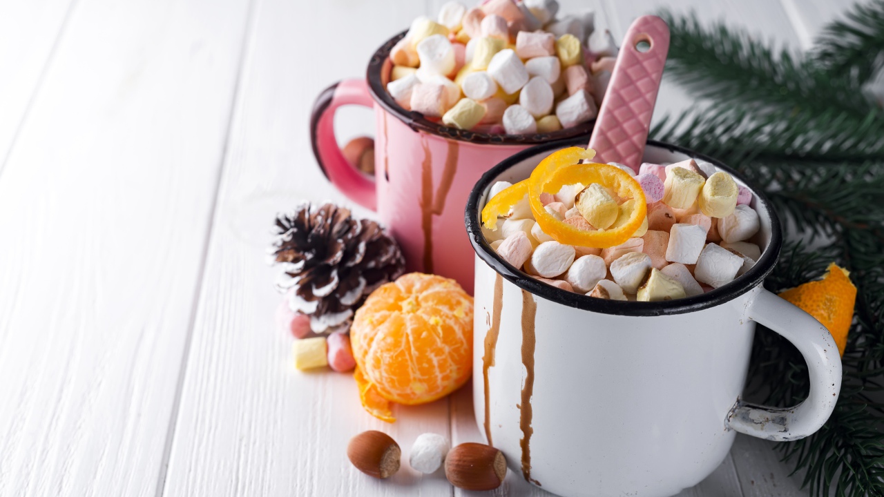 Две железные кружки с маршмеллоу на столе 